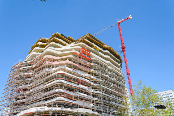 edificio alto in costruzione con impalcature sul cielo blu. - restoring office built structure elevator foto e immagini stock