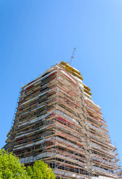 tall building in construction with scaffolding on blue sky. - restoring office built structure elevator imagens e fotografias de stock