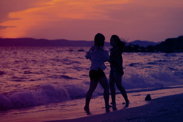 istock happy friend sisters with the sunset on the beach 959074466