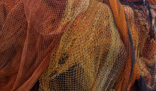 istock Orange fishing net is dried on the shore 959075956