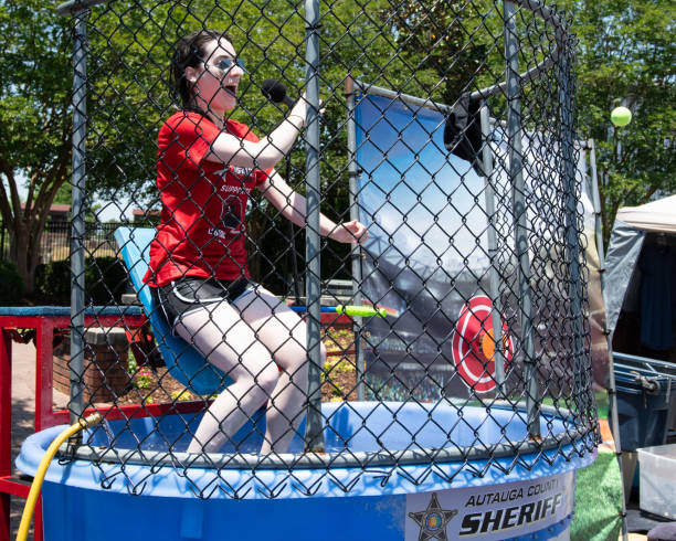 Amanda Curran getting dunked Prattville, Alabama, USA - May 12, 2018: Amanda Curran, a local WSFA tv personality, gets dunked at the Autauga County Sheriff's dunking booth at the 2018 Prattville Cityfest. dipping stock pictures, royalty-free photos & images