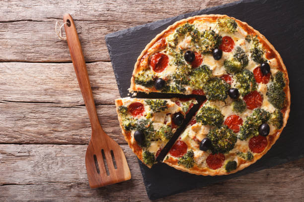 istock Savory Pie: Sliced Quiche with chicken, broccoli, tomatoes and olives close-up. horizontal top view 959081470