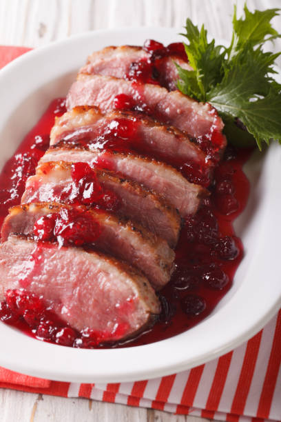 istock Sliced roast duck breast with cranberry sauce close-up. Vertical 959081690