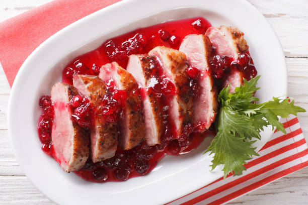 istock Sliced roast duck breast with cranberry sauce close-up. Horizontal top view 959084936