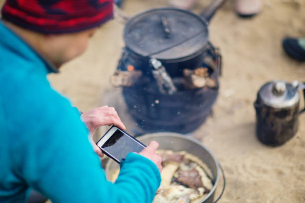 Man taking a picture of the lunch he cooked over a fire