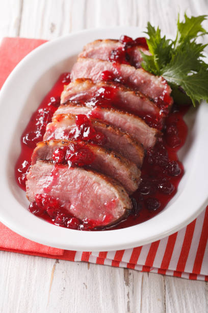 istock Festive food: roast duck breast with cranberry sauce close-up. vertical 959085824