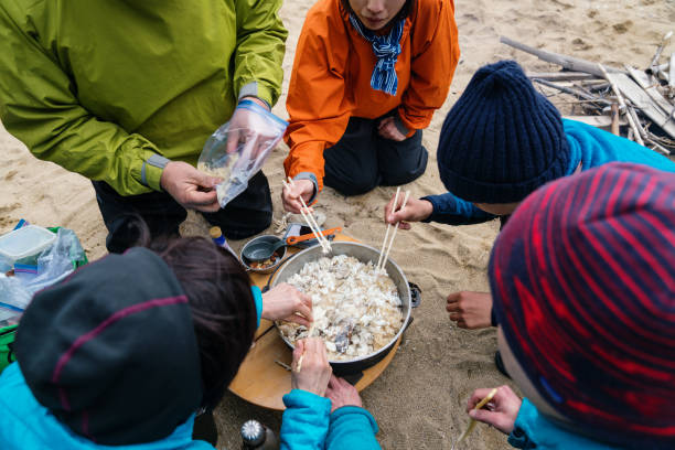istock Close up of people cooking outdoors while camping 959085892