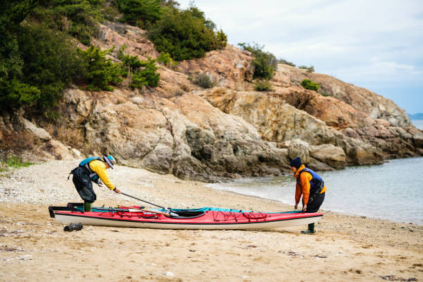istock Two women preparing a sea kayak on the beach 959086280