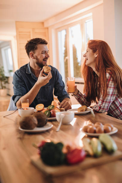 istock Happy couple communicating while having a meal at dining table. 959089386