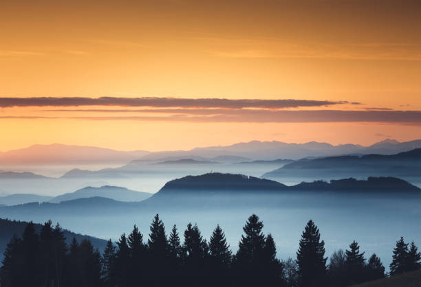 Foggy Sunset Foggy mountain landscape at sunset. spectacular view stock pictures, royalty-free photos & images