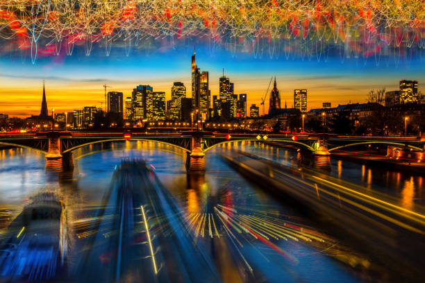Frankfurt am Main views and Ignatz Bubis bridge from passing cargo ship on Main River at sunset.Long exposure,city and vehicle lights line / Frankfurt, Germany / 05 March 2018