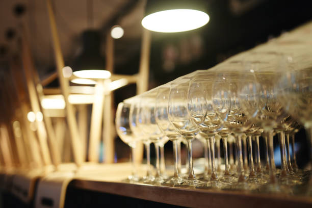 Wineglasses in closed bar Close-up view of clean empty wine glasses and overturned stools stacked on bar counter cafe transparent glass table stock pictures, royalty-free photos & images