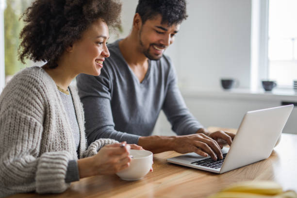 istock Happy black couple using laptop during breakfast time at home. 959093310