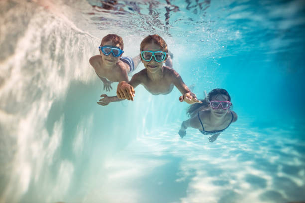 istock Happy kids swimming underwater 959095280