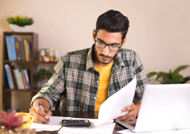 istock Man calculating bills in home office 959095538