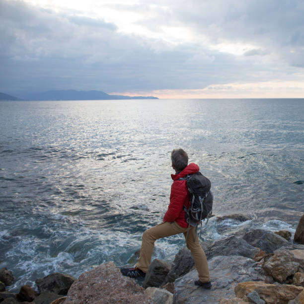 istock Mature man explores rocky shoreline and sea 959098470