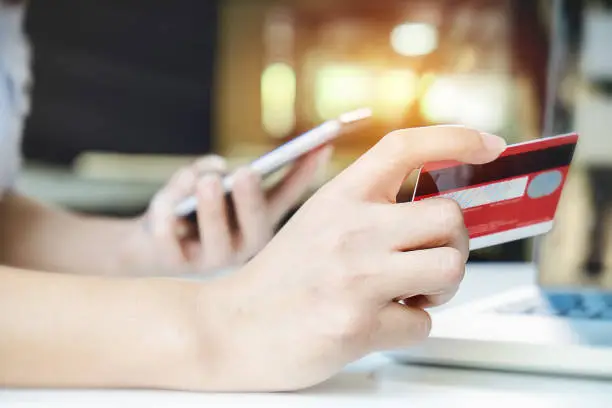asian young woman hands holding credit card and using laptop smart phone Online shopping.Online shopping concept