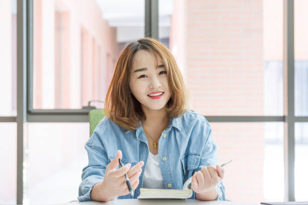 istock Smiling woman studying in the library 959106086