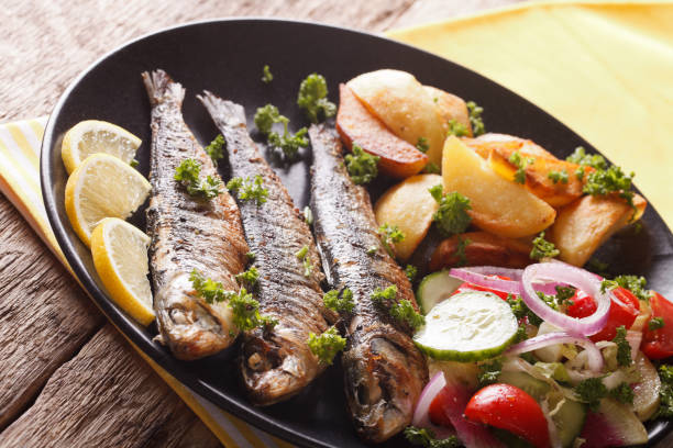 istock Grilled sardines with roasted potatoes and fresh salad closeup. Horizontal 959106612