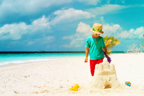 istock little boy building sand castle on beach 959109254