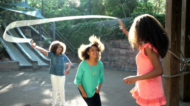 Three African-American sisters jumping rope