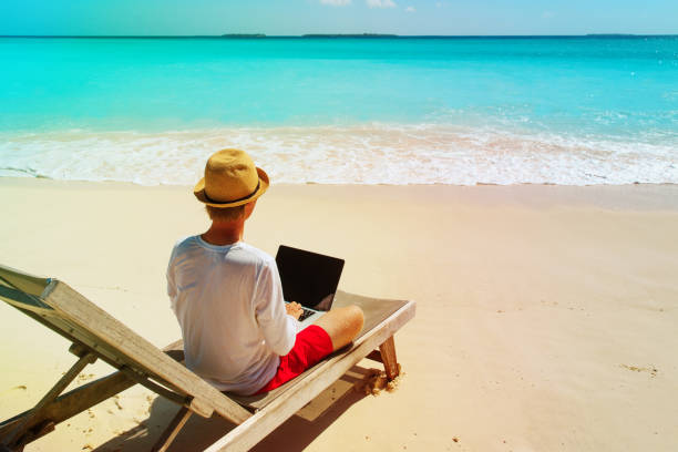 istock young man working on laptop at beach 959109788