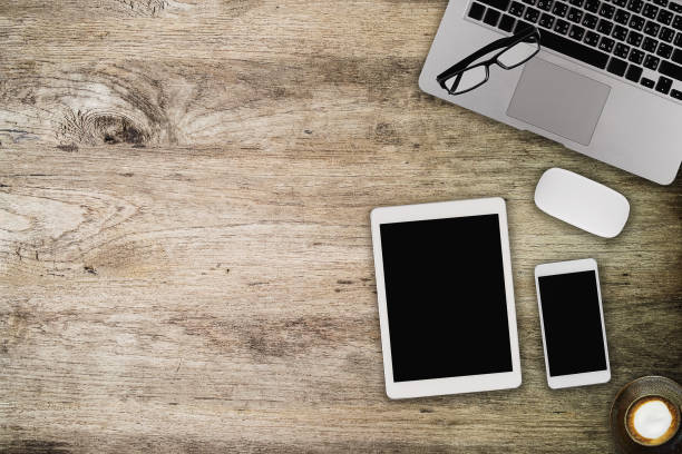 istock Wooden table with notepad, computer and green tea cup. View from above with copy space 959110174