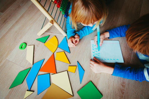 istock little boy and girl learn to write and calculate numbers 959110222