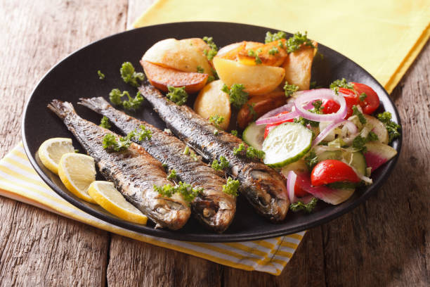 istock Fried sardines with roasted potatoes and fresh salad closeup. horizontal 959110328