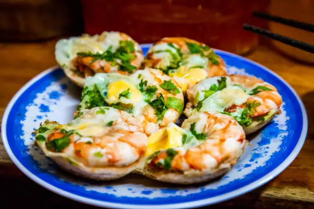 Savoury rice flour pancakes with quail eggs and shrimps, cooked in clay mould. Shot at Nha Trang, Vietnam.