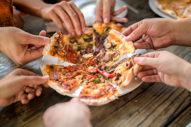 Close up image of friends having pizza at bar