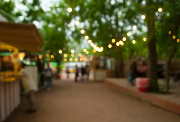 Beautiful bokeh background of the festival in the green city park.