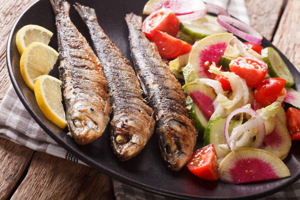 istock Mediterranean cuisine: grilled sardines with fresh vegetable salad close-up. horizontal 959116280