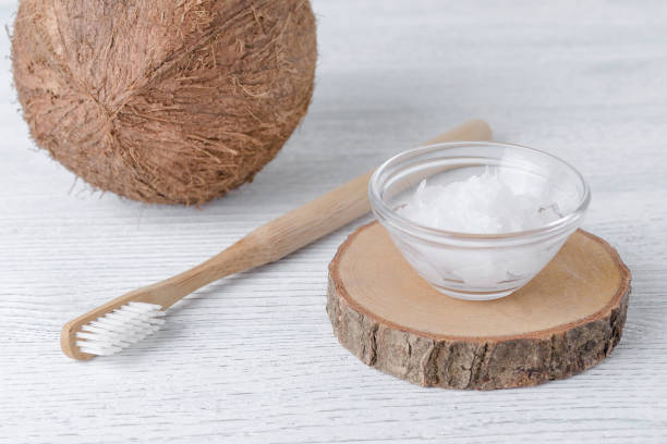 зубная паста кокосового масла, натуральная альтернатива для здоровых зубов, деревянная зубная щетка - pulling стоковые фото и изображения