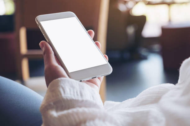 istock Mockup image of hands holding white mobile phone with blank desktop screen 959120020