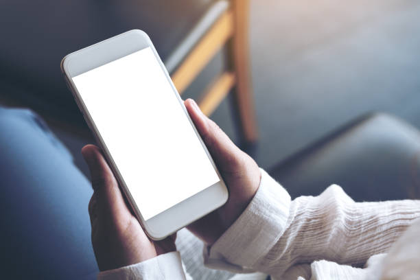 istock Mockup image of hands holding white mobile phone with blank desktop screen 959120022