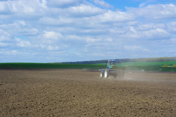 istock The process of spreading a mineral granulated fertilizer with an aggregate attached to a tractor 959123806