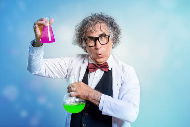Portrait of a crazy scientist doing experiment. He wears lab coat and bow tie, holds test tubes and makes a face.