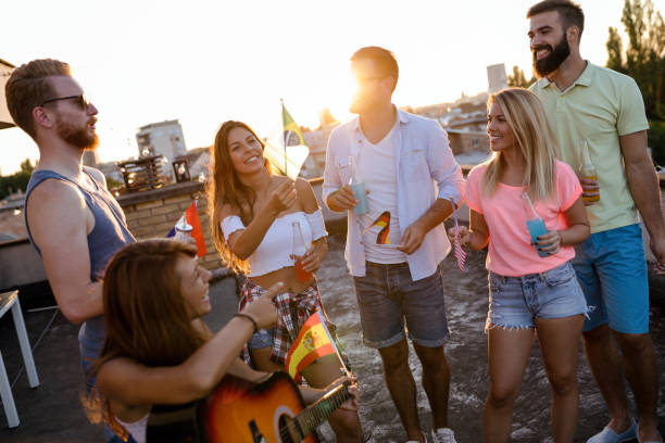 istock Group of happy friends having party on rooftop 959140990