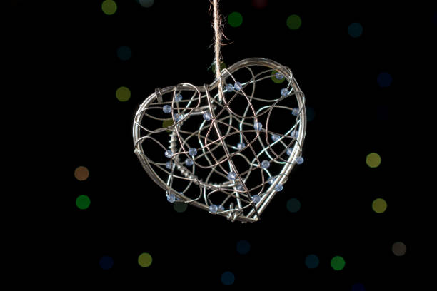 istock Heart shaped metal cage on bokeh light background 959141860