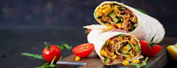 Burritos wraps with beef and vegetables on  black background. Beef burrito, mexican food. Burritos wraps with beef and vegetables on  black background. Beef burrito, mexican food. burrito photos stock pictures, royalty-free photos & images