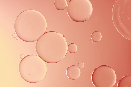 Water and oil on pink background - Abstract macro