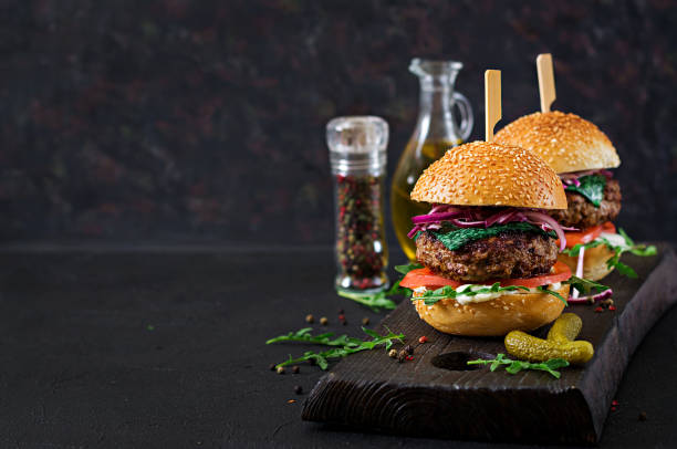istock Big sandwich - hamburger burger with beef,  tomato, basil cheese and arugula. 959145444