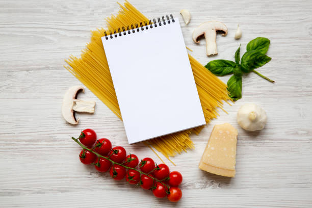 istock Different ingredients for cooking pasta with notebook on a white wooden background. Top view. Flat lay. From above. Space for text. 959147864