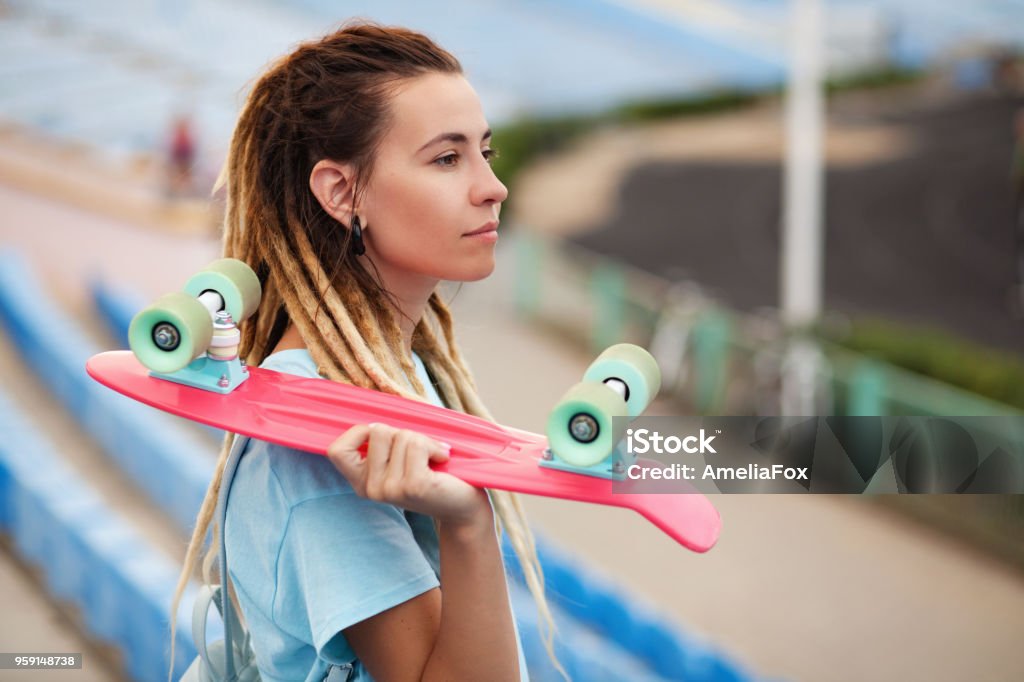 Young woman with skateboard in the stadium Beautiful young woman with skateboard in the stadium Adult Stock Photo