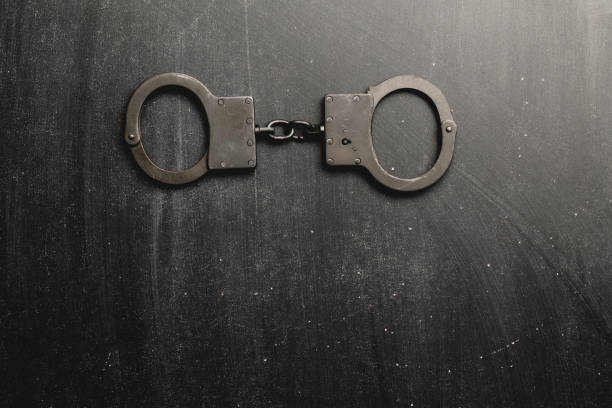 istock Metal handcuffs with dark background, 959153478