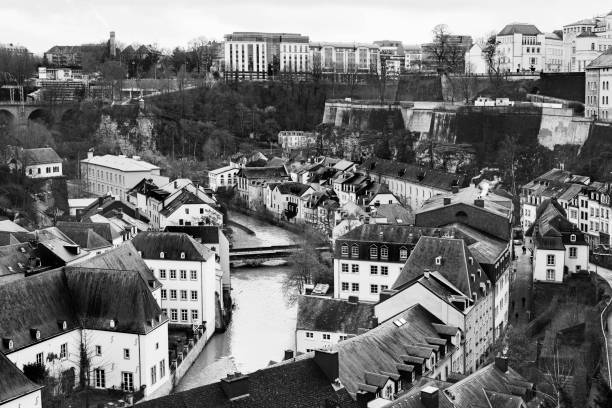 a view of Alzette River passing through the Grund Quarter of Luxembourg City, Luxembourg, with its typical houses with black slate roofs, in black and white