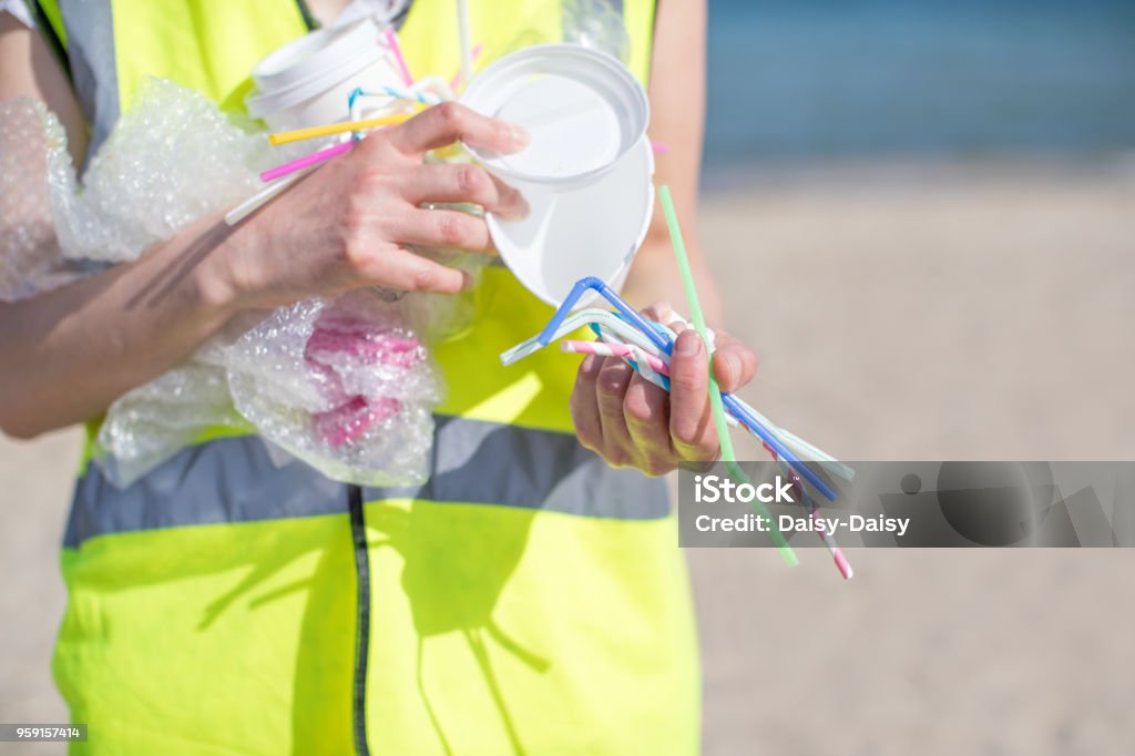 Close Up Of Person Collecting Plastic Waste From Polluted Beach Drinking Straw Stock Photo