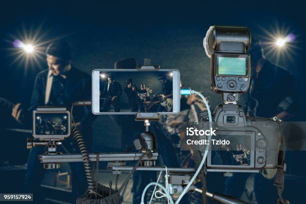 Professional Set Of Camera With Smart Mobile Phone And Action Camera On Tripod Over Musician Band Holding The Microphone Singing A Song And Playing Music Instrumentlive Streaming For Musical Concept Stock Photo - Download Image Now