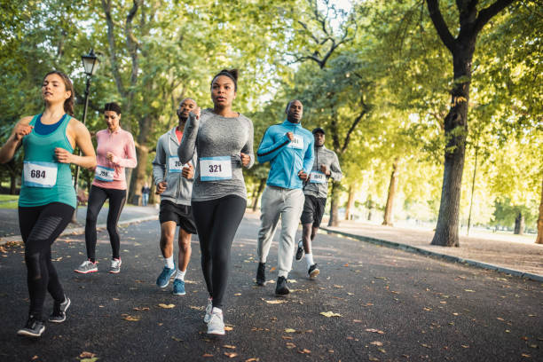 istock Group of people running track together in a park 959161682